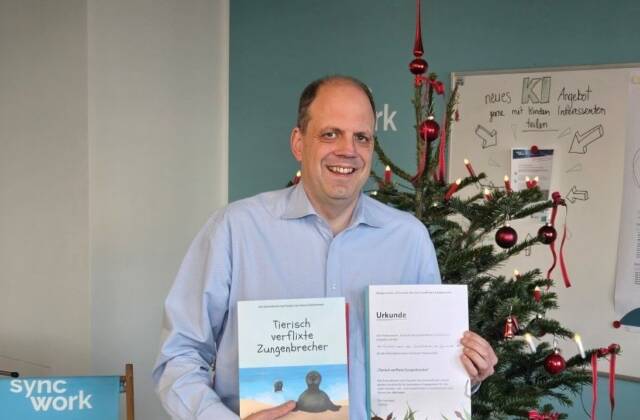 Martin Hartmann, Vorstandsmitglied von Sync-Work mit Kinderbuch und Patenschaftsurkunde
