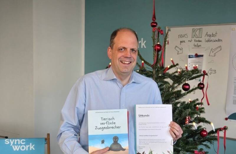 Martin Hartmann, Vorstandsmitglied von Sync-Work mit Kinderbuch und Patenschaftsurkunde