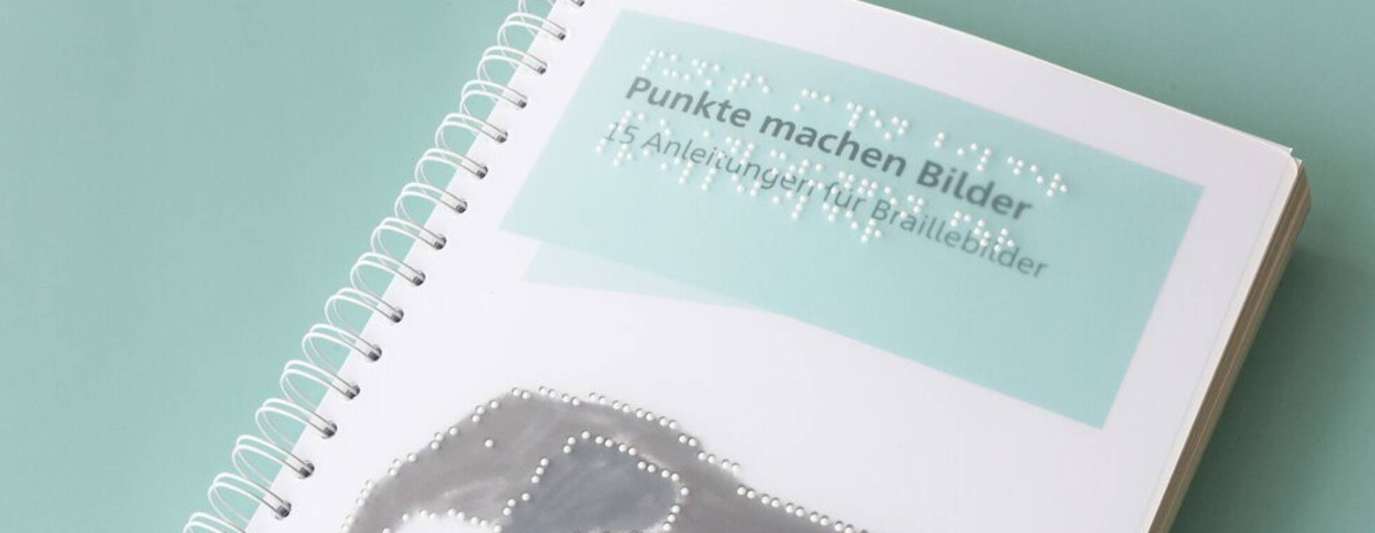 Das Ringbuch auf mintgrünem Hintergrund. Auf dem Cover ein Elefant in Braille und der Titeltext "Punkte machen Bilder. 15 Anleitungen für Braillebilder"